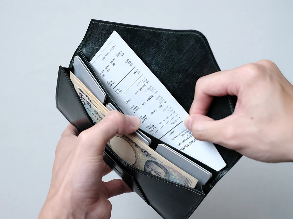 カード段の奥もポケットになっています。手前の札入れと紙幣を分けて入れて頂くことができ、領収書やレシートの収納としてもお使い頂けます。深さがあるため、パスポートや通帳など、サイズの大きな物も収まります。