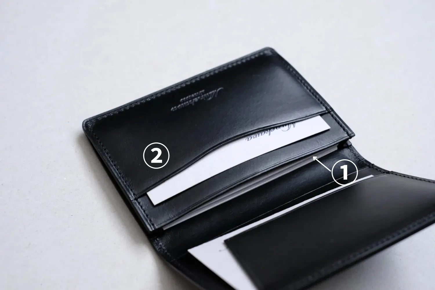 本体側の2つのポケット<br>
①メインポケット部分は、一般的なサイズの名刺がおよそ20枚ほど収納可能です。<br>
②サブポケットは名刺交換時にいただいた名刺を一時的に収納しておいたり、よく使うクレジットカードを入れておくのにも便利です。