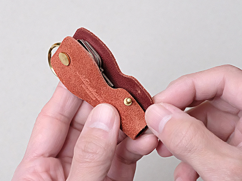 ホックを使わず、小さい真鍮ギボシをキーケースの側面に使うことで、余計な凹凸や厚みが出ず、なおかつ鍵や周囲を保護するための蓋として機能します。
